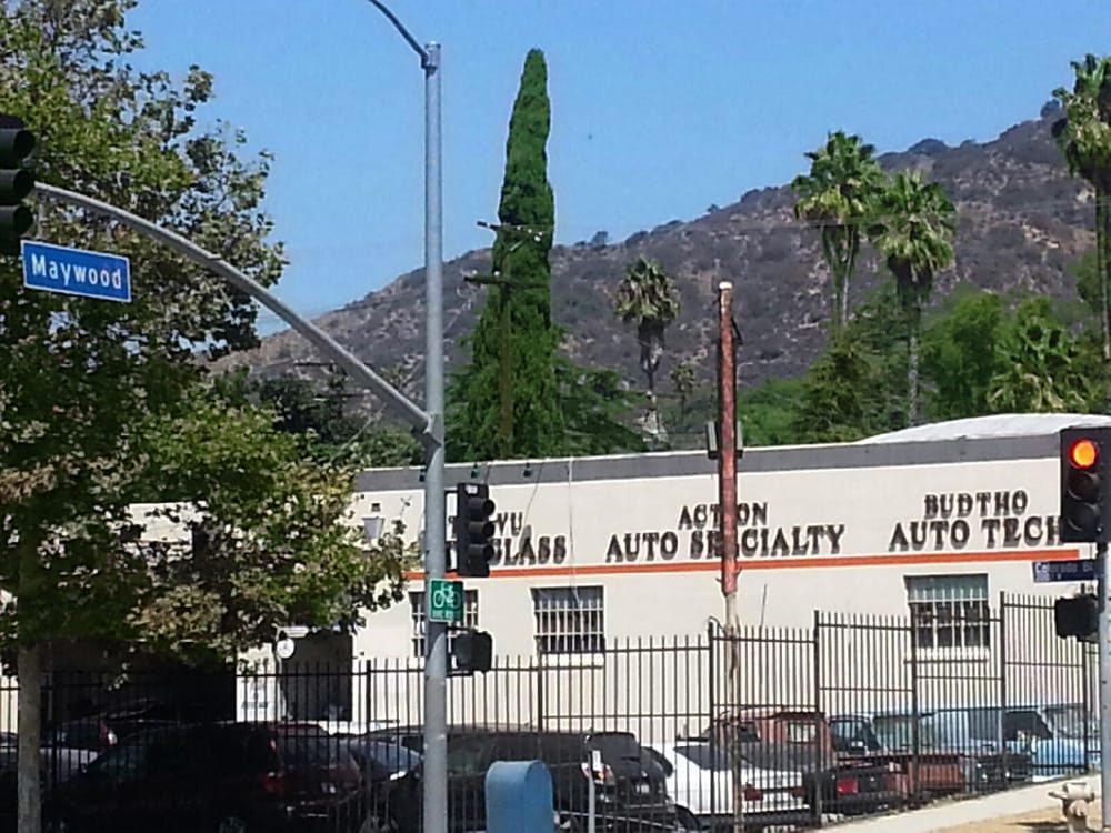 The long cream building at Colorado Boulevard and Maywood Avenue with Budtho Auto Tech painted at the end of it.