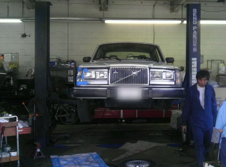 A Volvo sedan up on the lift in our garage, with Adam walking past.